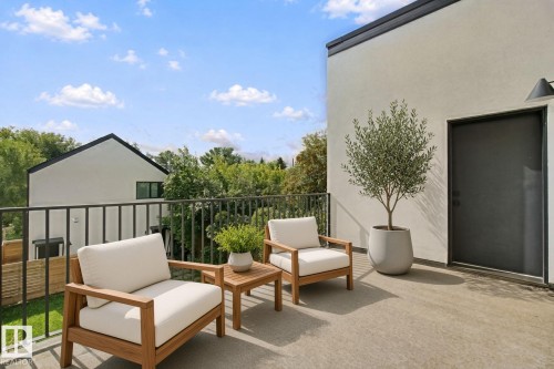 Expansive rooftop deck with concrete flooring, stucco exterior, and black metal railing - 10925 University Avenue Nw, Edmonton, AB 