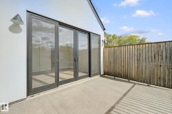 Concrete patio with a wood-plank privacy fence and modern exterior lighting - 