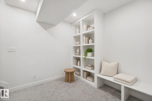 Built-in shelving with recessed lighting, integrated bench seating, and light-toned carpeting - 10925 University Avenue Nw, Edmonton, AB 