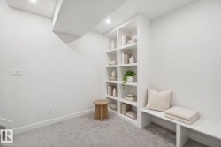 Built-in shelving with recessed lighting, integrated bench seating, and light-toned carpeting - 