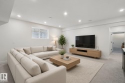 Recessed lighting illuminates the open living area featuring light-toned carpeting and a built-in media console - 