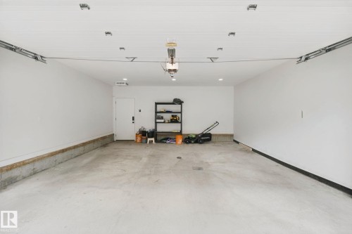 Spacious garage with a concrete floor, painted walls, and an overhead garage door opener system - 10925 University Avenue Nw, Edmonton, AB 