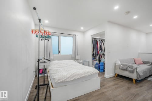Recessed lighting illuminates the space, featuring wood-finish flooring and a window with white trim - 10925 University Avenue Nw, Edmonton, AB 