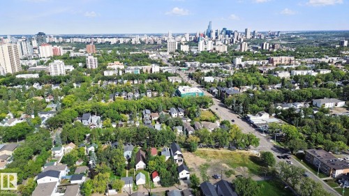 Urban landscape featuring a dense collection of residential homes, tree-lined streets, and a prominent city skyline in the background - 10925 University Avenue Nw, Edmonton, AB 