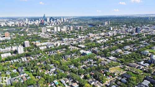 Urban landscape with a prominent city skyline, residential areas featuring mature trees, and a river winding through the expanse - 10925 University Avenue Nw, Edmonton, AB 