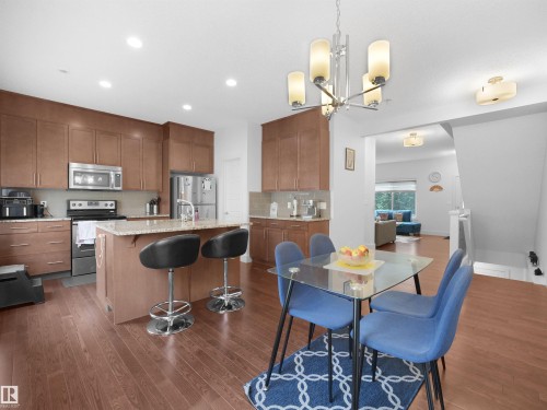 Kitchen featuring wood-finish flooring, recessed lighting, and a center island with a stone countertop - #40 2003 Rabbit Hill Rd Nw, Edmonton, AB 