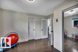 Hallway featuring dark wood-finish flooring, white baseboards, and two flush-mount ceiling lights - 
