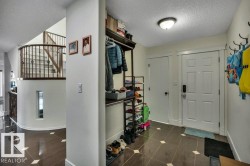 Entry foyer featuring diamond-patterned floor tiles, a six-panel front door with smart lock, and an overhead flush-mount light fixture - 