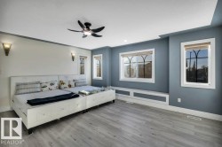 Spacious room featuring wood-finish flooring, a contemporary ceiling fan, and recessed lighting - 