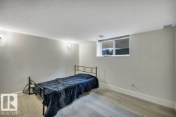 Spacious room featuring wood-finish flooring, light neutral wall tones, and recessed lighting - 