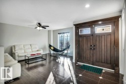 Grand entryway featuring double dark wood doors with transom windows, detailed trim work, and dark tile flooring with light accent squares - 