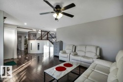 Open-concept living space with dark wood-finish flooring and a contemporary ceiling fan with lighting - 