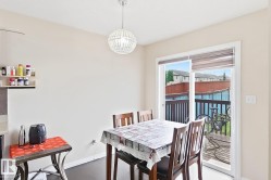 Sliding glass door access to an outdoor deck, overhead pendant lighting, and dark wood-finish flooring - 