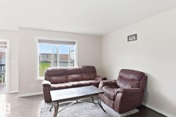 Wood-finish flooring, neutral wall tones, white trim, and a window with blinds - 