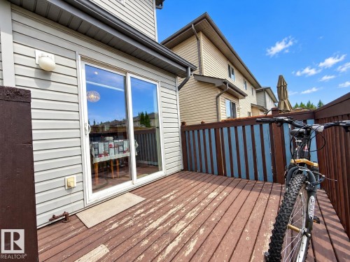 Sliding glass door, exterior wall lighting, and a wood-finish deck - 2829 18A Avenue Nw, Edmonton, AB 