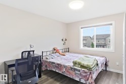 Light-filled room featuring a large window, neutral wall tones, wood-finish flooring, and a flush-mount ceiling light - 