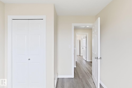 Neutral wall tones, panel-style interior doors, bi-fold closet doors, and wood-finish flooring - 2829 18A Avenue Nw, Edmonton, AB 
