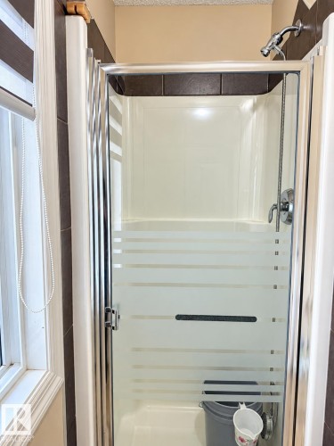 Shower enclosure with frosted glass door, chrome hardware, and tiled surround - 2829 18A Avenue Nw, Edmonton, AB 