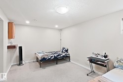 Recessed lighting and a flush-mount ceiling fixture illuminate this carpeted room - 