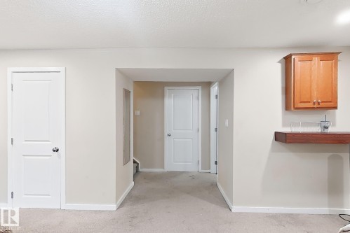 Neutral wall paint, light-toned carpeting, and white interior doors - 2829 18A Avenue Nw, Edmonton, AB 