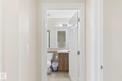 Bathroom featuring a vanity with wood-finish cabinetry, a single basin sink, and a wall-mounted mirror - 