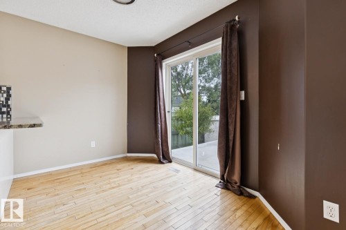 Light wood-finish flooring, sliding glass door, and a built-in counter with a mosaic tile backsplash - 1190 Potter Greens Drive Nw, Edmonton, AB 