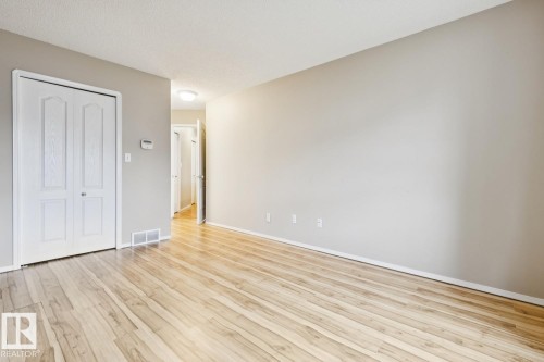 Light wood-finish flooring complements neutral wall tones - 1190 Potter Greens Drive Nw, Edmonton, AB 
