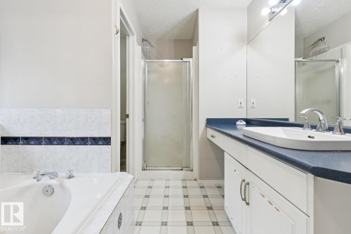 Vanity with integrated sink, chrome fixtures, and a large mirror - 1190 Potter Greens Drive Nw, Edmonton, AB 