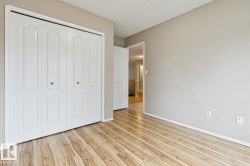 Wood-finish flooring, white bi-fold closet doors, and neutral wall tones - 