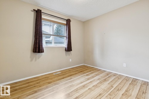 Wood-finish flooring, neutral wall paint, and white trim - 1190 Potter Greens Drive Nw, Edmonton, AB 
