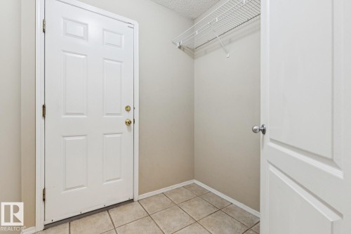 Tiled flooring, white interior door, wire shelving, neutral wall paint, and white trim - 1190 Potter Greens Drive Nw, Edmonton, AB 