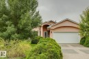 Stucco exterior with arched entryway and garage door framing - 1190 Potter Greens Drive Nw, Edmonton, AB 