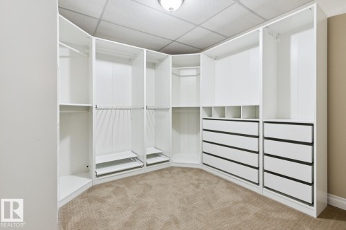 Built-in closet system featuring white cabinetry, multiple shelves, integrated drawers, and hanging rods - 1190 Potter Greens Drive Nw, Edmonton, AB 