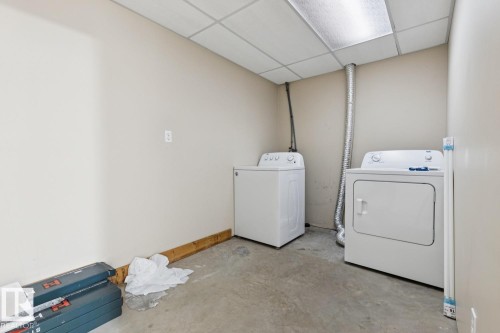 Laundry area featuring a drop ceiling, concrete floor, and white walls - 1190 Potter Greens Drive Nw, Edmonton, AB 