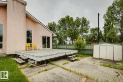 Exterior featuring stucco siding, multiple windows, a rear deck with steps, a sliding glass door, and a detached storage shed - 