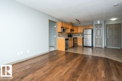 Hardwood flooring, full kitchen with wood-finish cabinetry, stainless steel appliances, tile backsplash, and track lighting - 