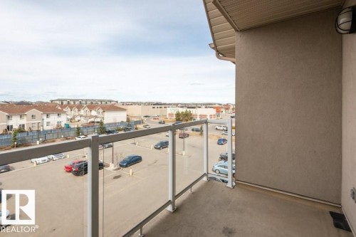 Private balcony featuring glass panel railings and a concrete floor - 401 5005 165 Avenue Nw, Edmonton, AB 