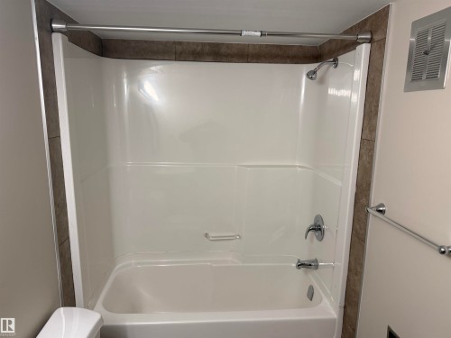 Tub and shower combination with chrome fixtures and grab bar - #205 10335 117 St Nw, Edmonton, AB 