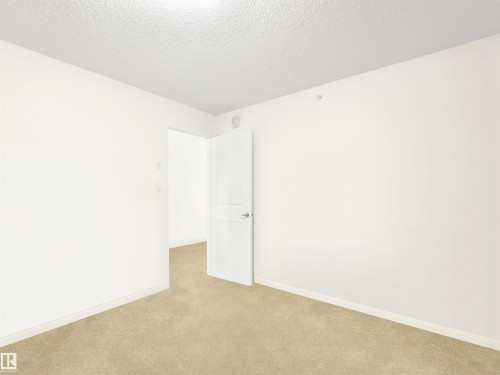 Neutral tone wall paint with textured ceiling and carpet flooring - #414 340 Windermere Rd Nw, Edmonton, AB 