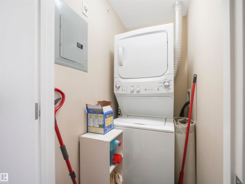 Dedicated laundry area with a stackable washer and dryer unit - #414 340 Windermere Rd Nw, Edmonton, AB 