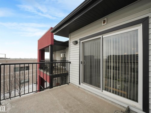 Exterior balcony featuring a concrete floor, black metal railings, and vinyl siding - #414 340 Windermere Rd Nw, Edmonton, AB 