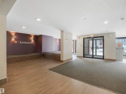 Building entryway featuring wood-finish flooring, recessed lighting, and wall sconces - 