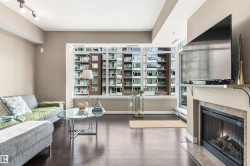 Floor-to-ceiling windows, dark wood-finish flooring, recessed lighting, track lighting, and a built-in fireplace - 