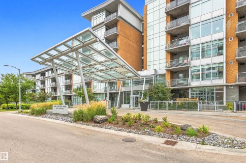 Modern multi-story building featuring brick and glass exterior, multiple private balconies, and a distinctive glass canopy entrance - #416 2510 109 St Nw, Edmonton, AB 