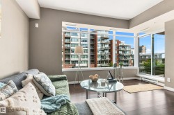 Expansive window wall, rich wood-finish flooring, sliding glass door access, light neutral wall tones, and recessed ceiling lighting - 