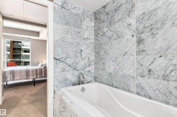 Built-in soaking tub with a deck-mounted faucet, surrounded by tiled walls - 