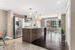 Kitchen featuring stainless steel appliances, wood-finish cabinetry, and a center island with pendant lighting - 