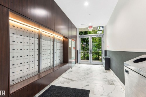 Mailbox wall with integrated lighting, glass exit doors, and white tile flooring - #416 2510 109 St Nw, Edmonton, AB 
