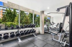 Fitness center featuring extensive full-height windows, rubber tile flooring, and integrated lighting - 