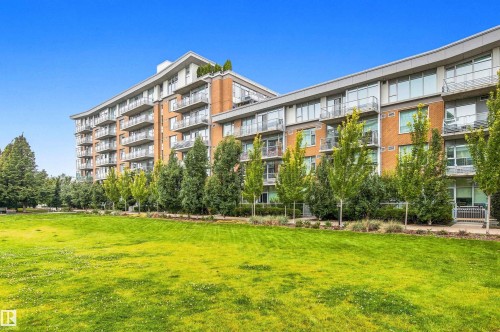 Multi-story building featuring brick and panel facade, multiple balconies with metal railings, and a prominent rooftop element - #416 2510 109 St Nw, Edmonton, AB 
